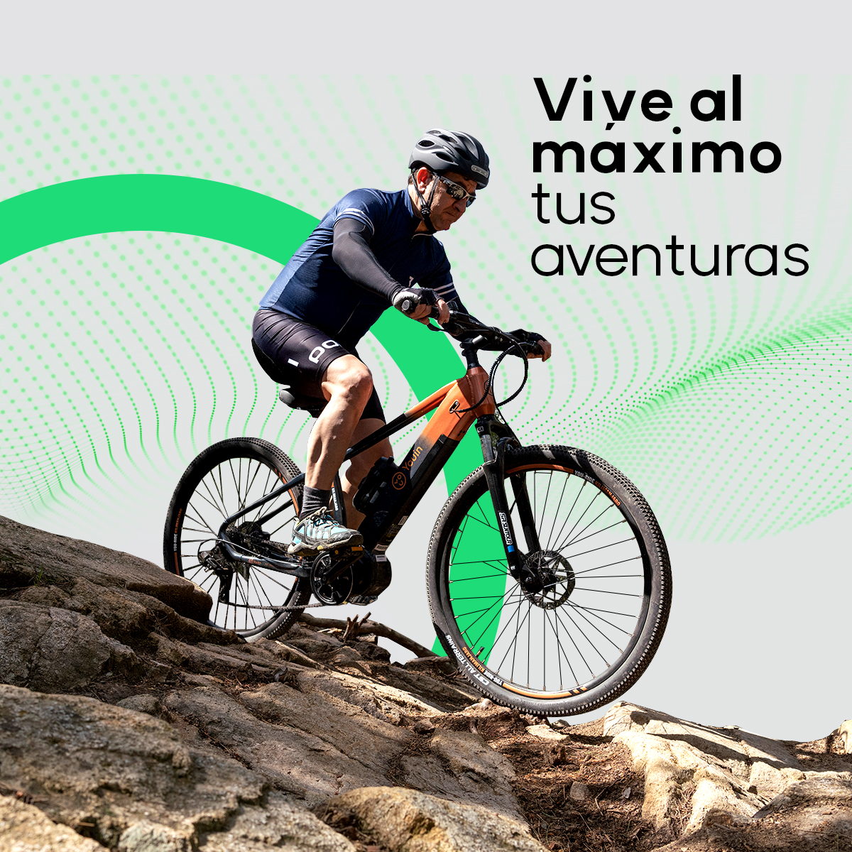 Uomo in sella a una mountain bike arancione e nera su un sentiero roccioso.