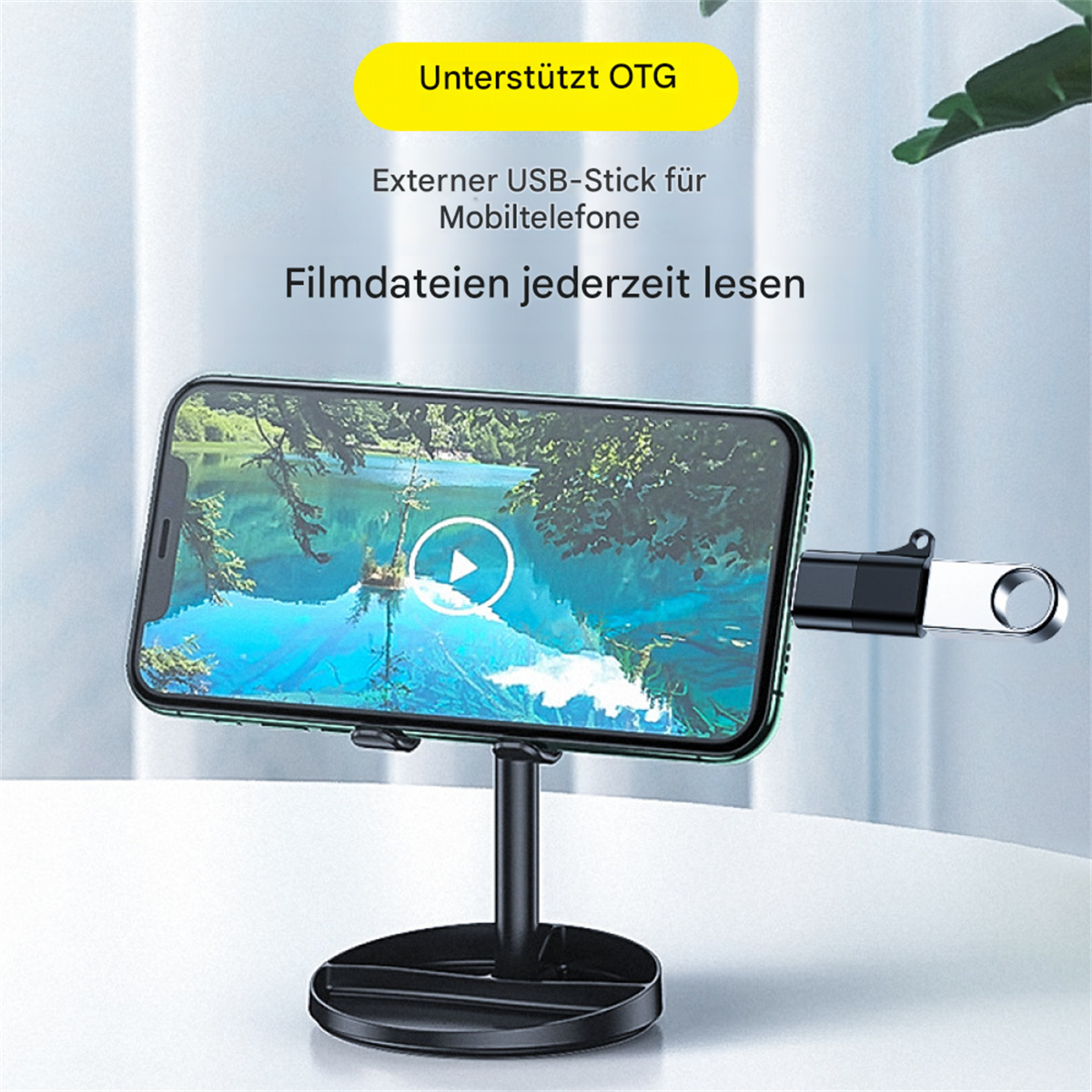 Telefon auf einem Ständer mit angeschlossenem USB-Stick. Text: Externer USB-Stick für Mobiltelefone.
