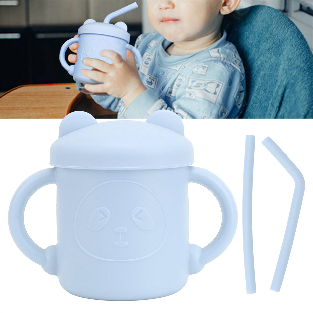 Ein Baby hält einen blauen Becher mit Pandagesicht. Der Becher hat Henkel, einen Deckel und einen Strohhalm.