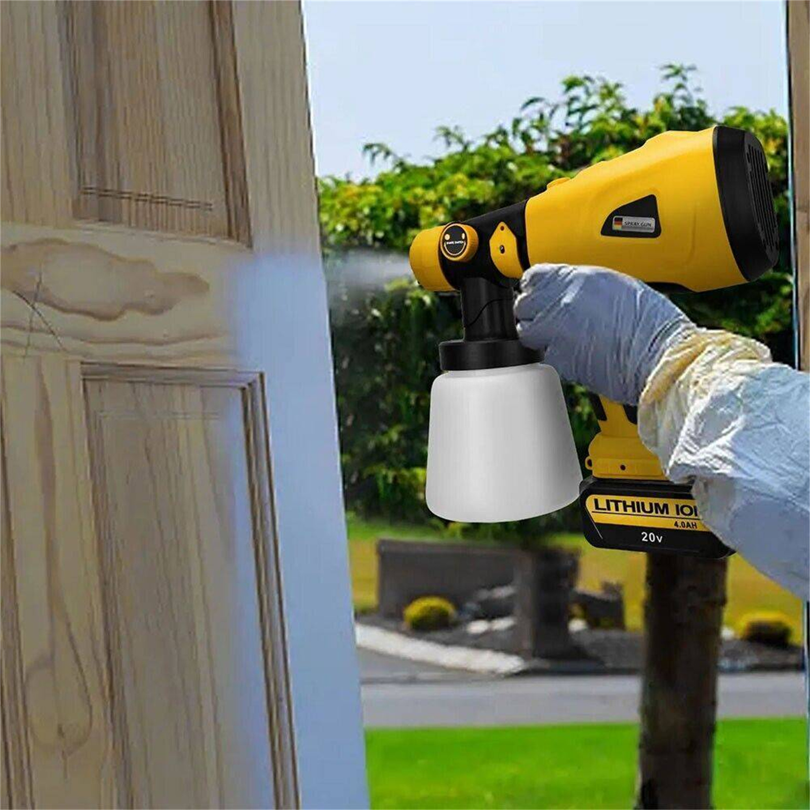 Eine Person sprüht Farbe auf eine Holztür mit einem gelb-schwarzen Farbsprühgerät.