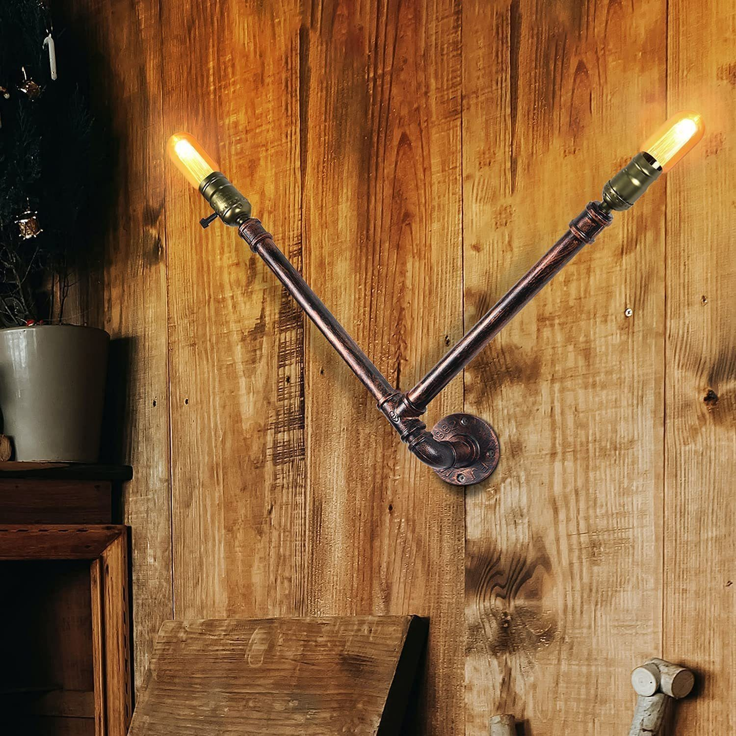 Due lampadine montate su un muro di legno, a forma di V. Le lampadine sono accese, emettendo una luce calda.
