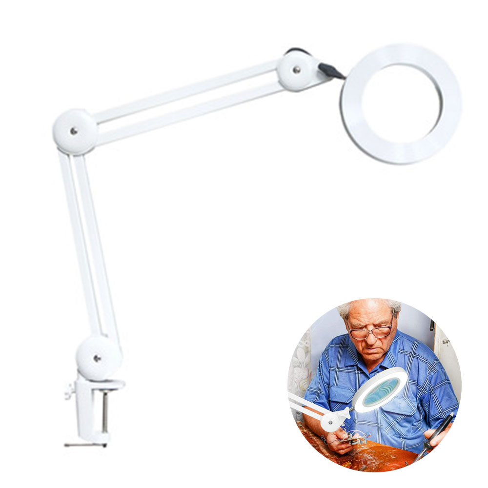 Weiße Schreibtischlampe mit Lupe. Ein älterer Mann benutzt sie an einem Tisch. Weißer Hintergrund.