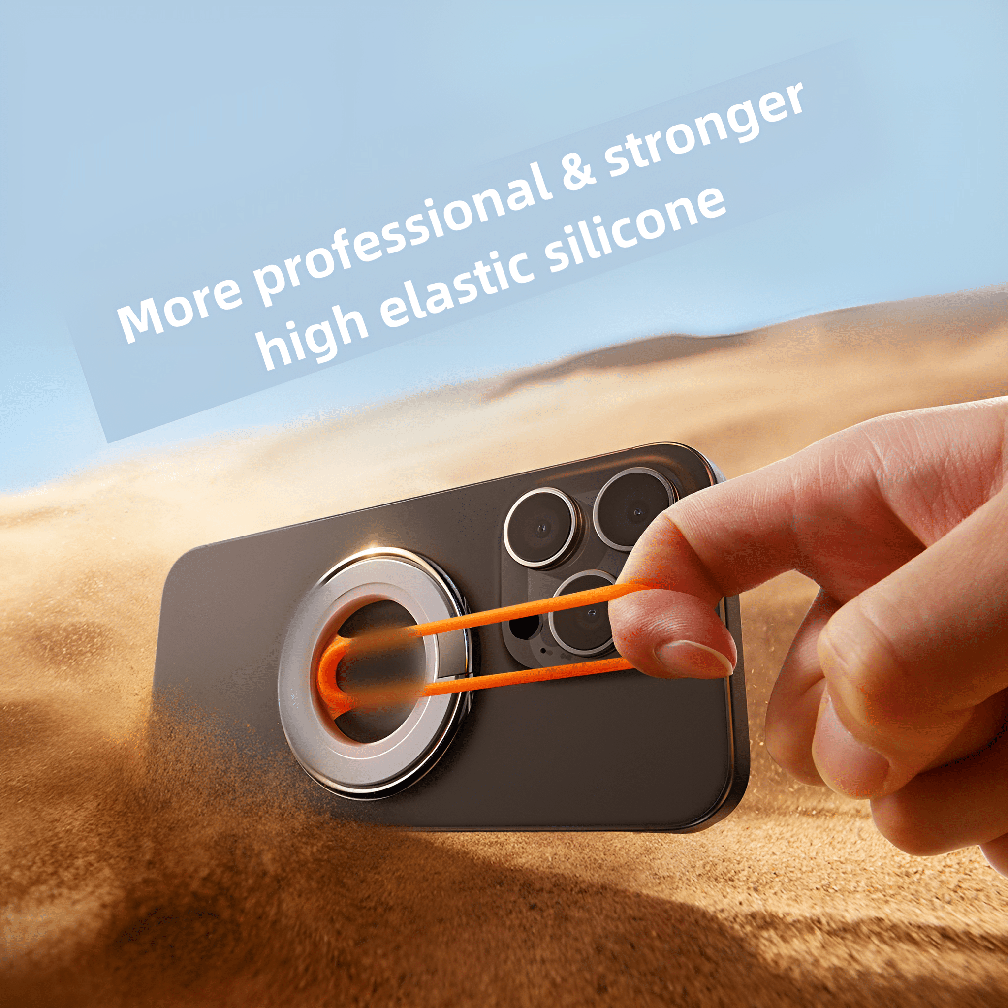 Eine Hand hält ein Telefon mit ringförmigem Halter. Das Telefon liegt im Sand.