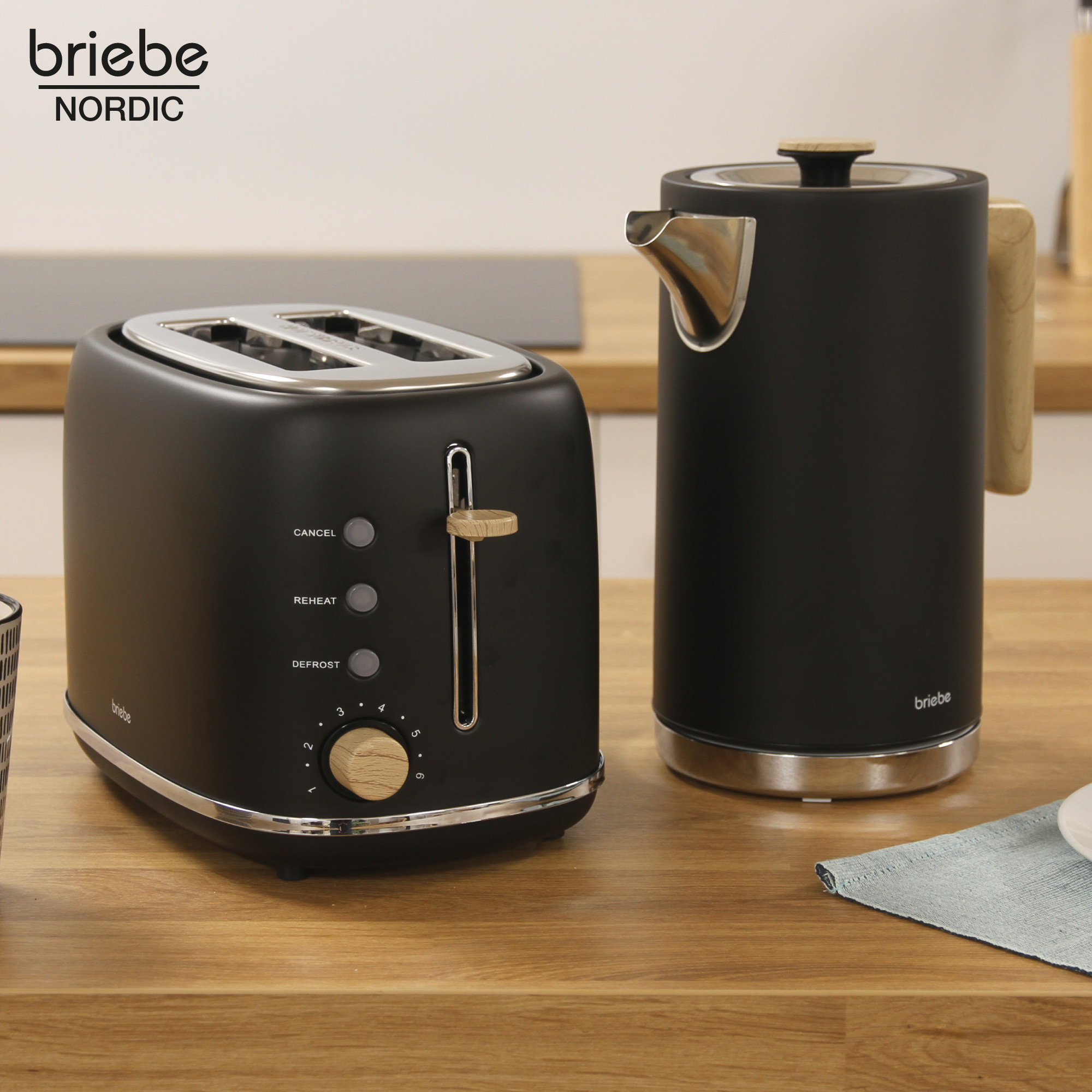 Schwarzer Toaster und Wasserkocher auf Holztheke. Der Toaster hat einen Holzgriff, der Wasserkocher einen Holzdeckel.