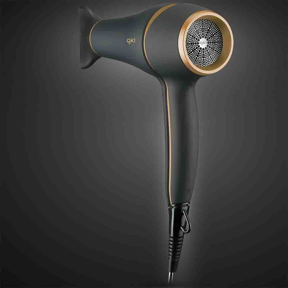 Asciugacapelli nero e oro su sfondo scuro. L'asciugacapelli ha un design elegante.