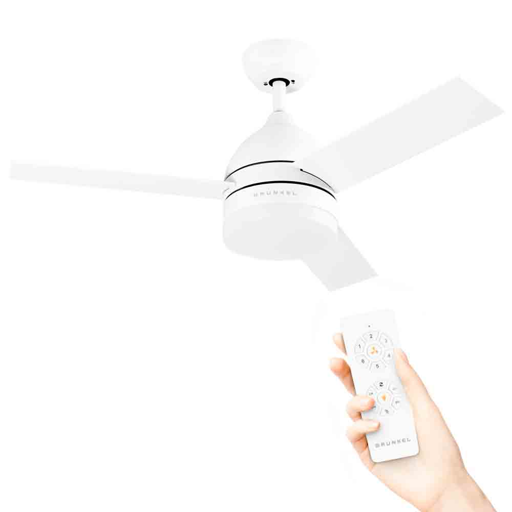Biały wentylator sufitowy z trzema łopatkami i pilotem w dłoni.