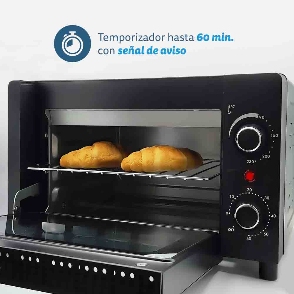 All'interno di un forno da banco nero. Due croissant su una griglia. Il forno ha controlli di temperatura e timer.