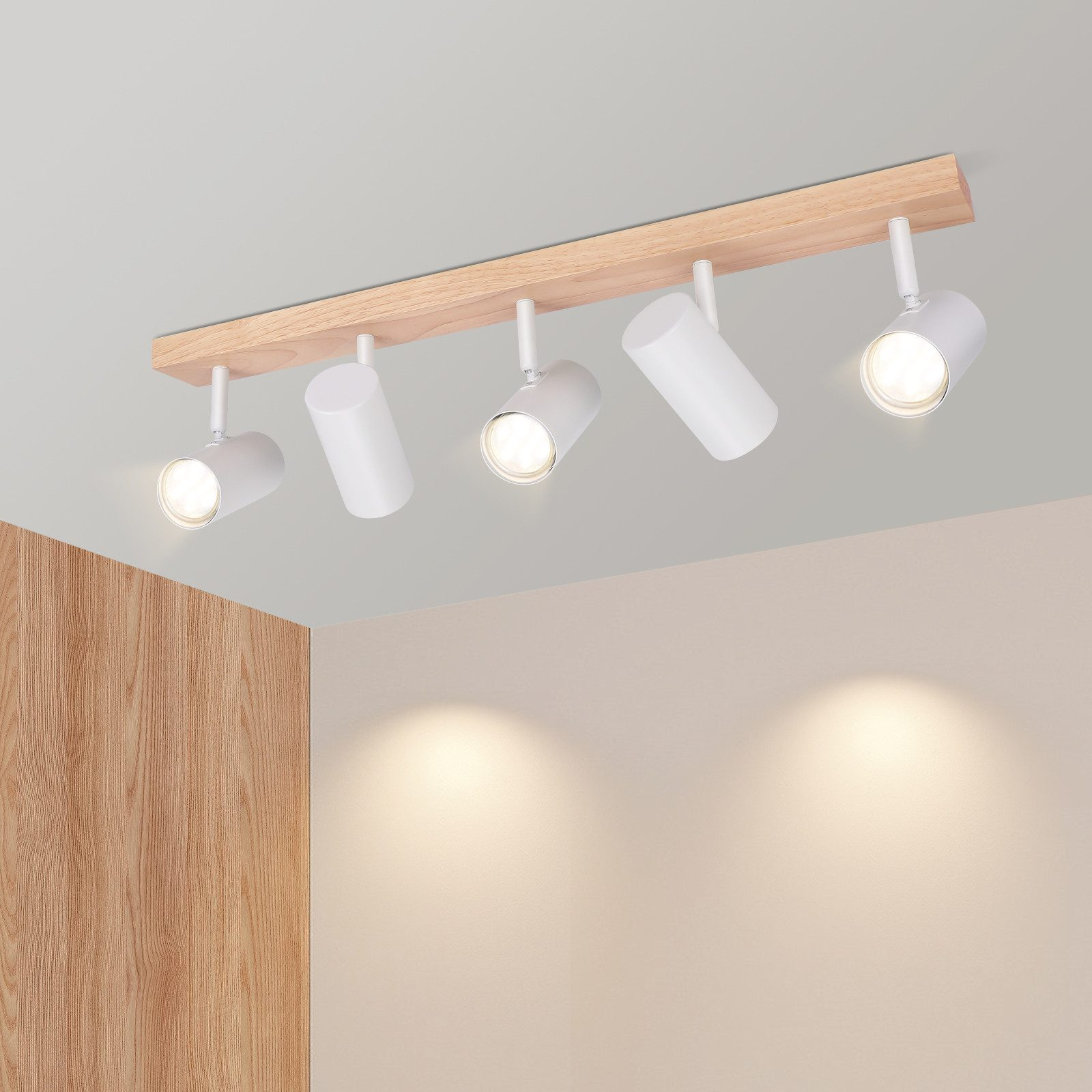 Faretti a soffitto montati su una trave di legno. I faretti sono bianchi.