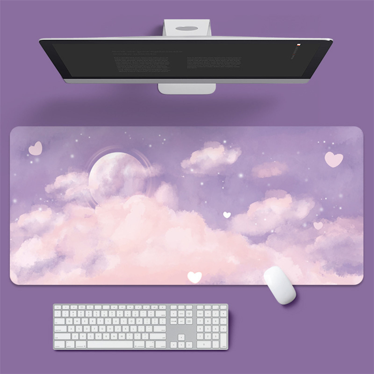 Ein Schreibtisch-Setup mit einem großen Mousepad mit einem rosa-lila Himmel mit Wolken, Mond, Tastatur und Maus.
