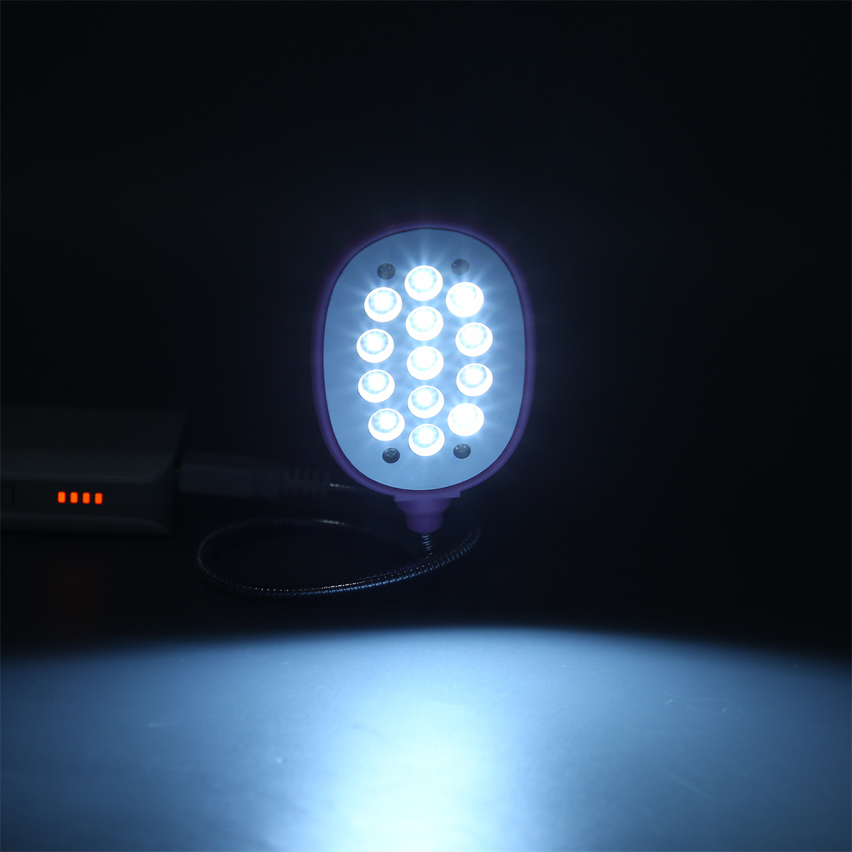 Eine lila Lampe mit 12 Lichtern. Die Lampe ist mit einem USB-Kabel verbunden und eingeschaltet.