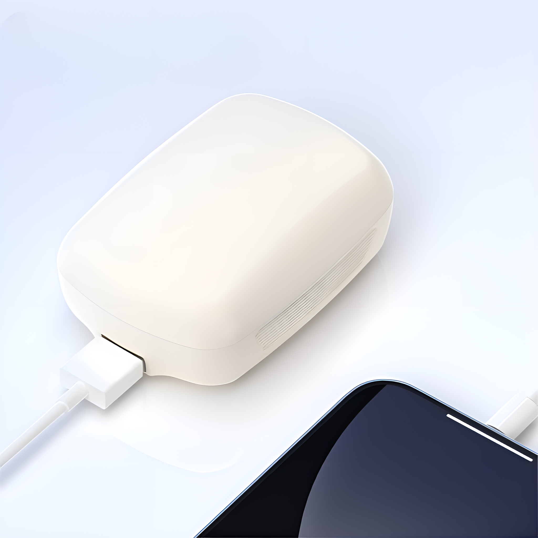 Eine weiße Powerbank mit eingestecktem weißen Kabel und ein schwarzes Smartphone mit weißem Kabel. Der Hintergrund ist weiß.