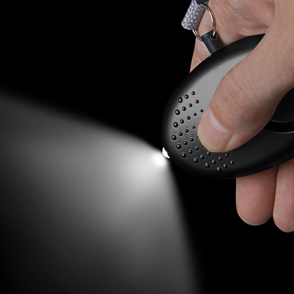 Ein schwarzes Alarmgerät mit hellem Lichtstrahl im Dunkeln. Es wird von einer Hand gehalten.