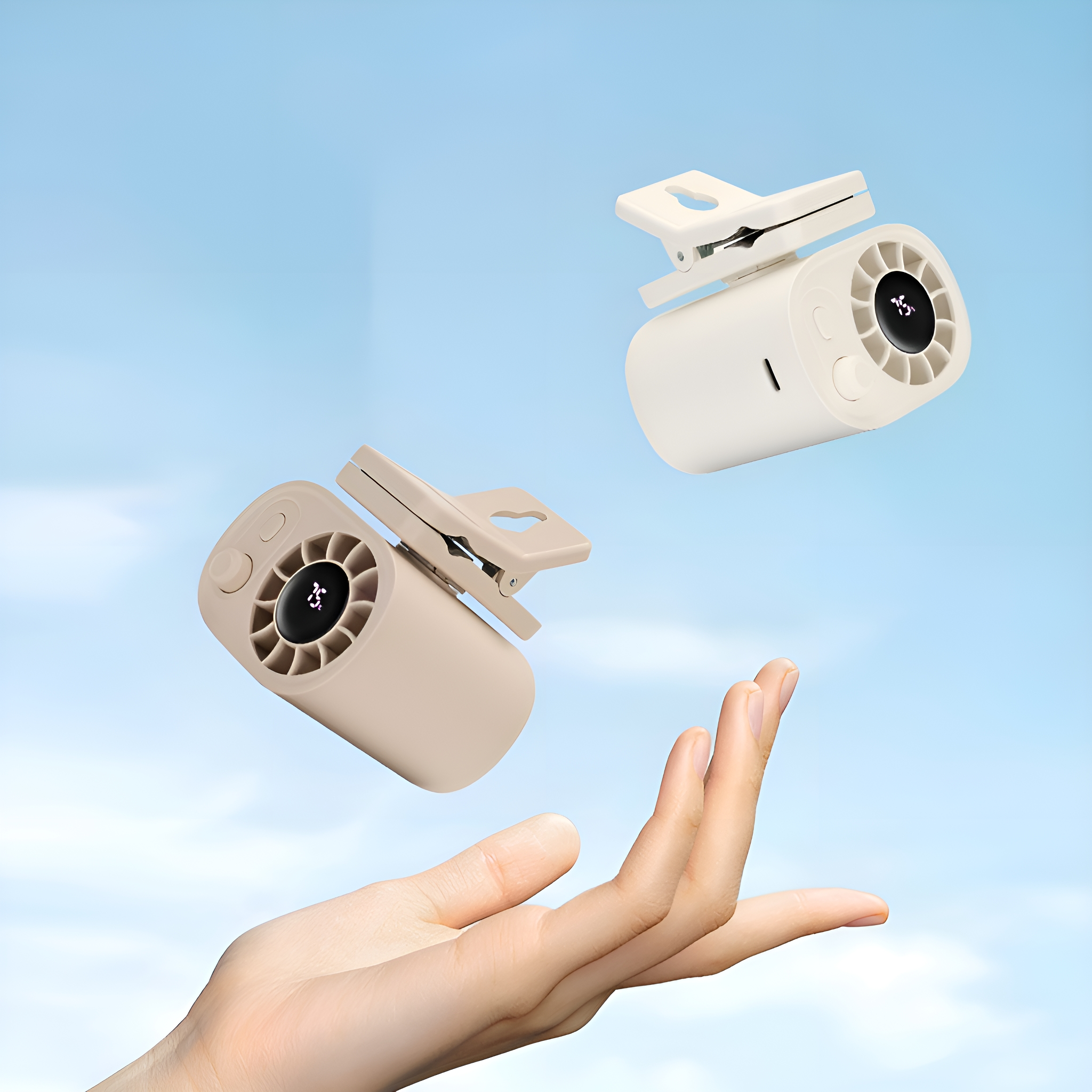 Zwei kleine Ventilatoren mit Clips schweben in der Luft, einer wird von einer Hand gehalten.