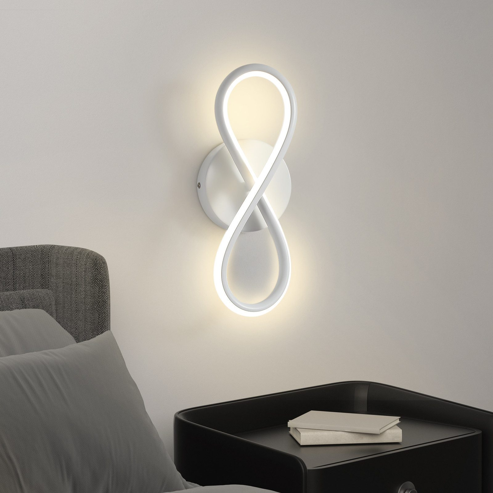 Un'applique bianca a forma di simbolo dell'infinito, illuminata.