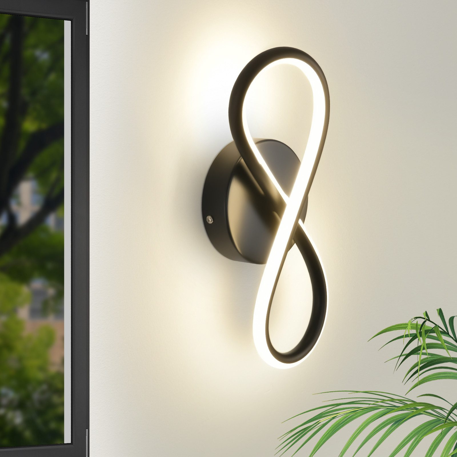 Un'applique nera a forma di simbolo dell'infinito, illuminata.
