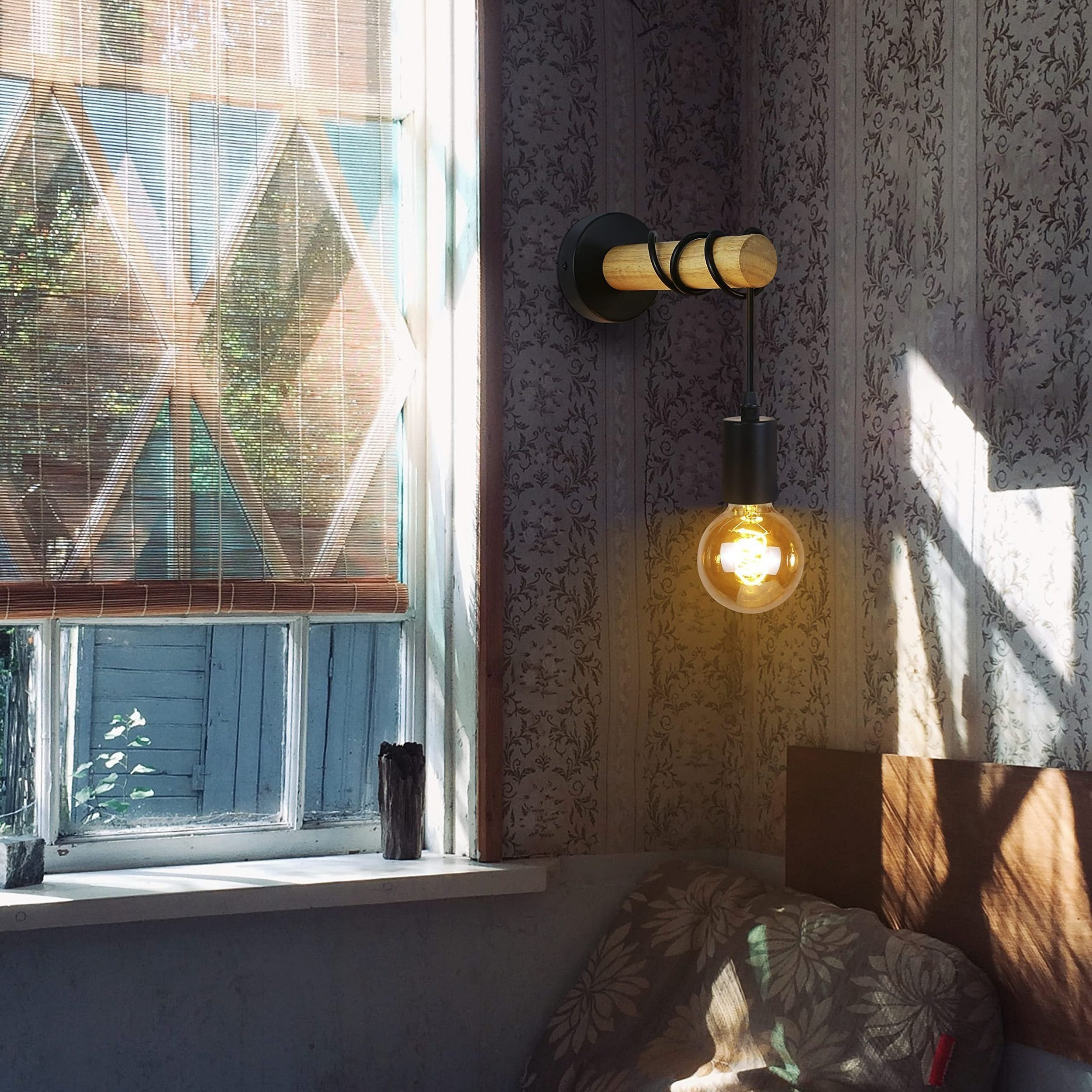 Una lampada da parete con una lampadina, accanto a una finestra con un motivo a finestra.