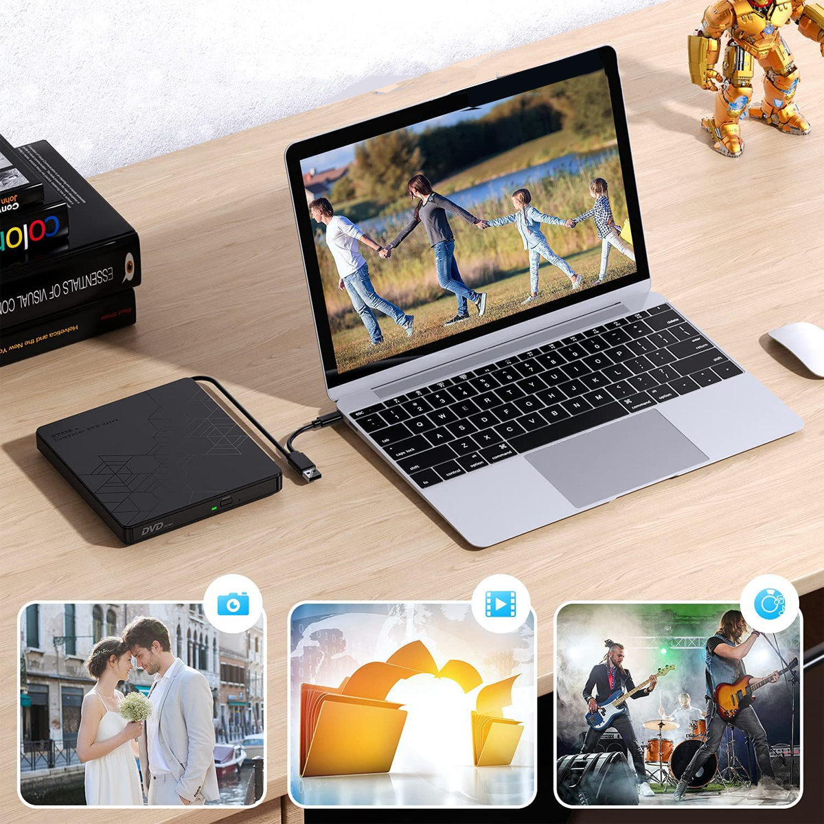 Laptop mit Fotos, DVD-Laufwerk und Roboter auf einem Holzschreibtisch.