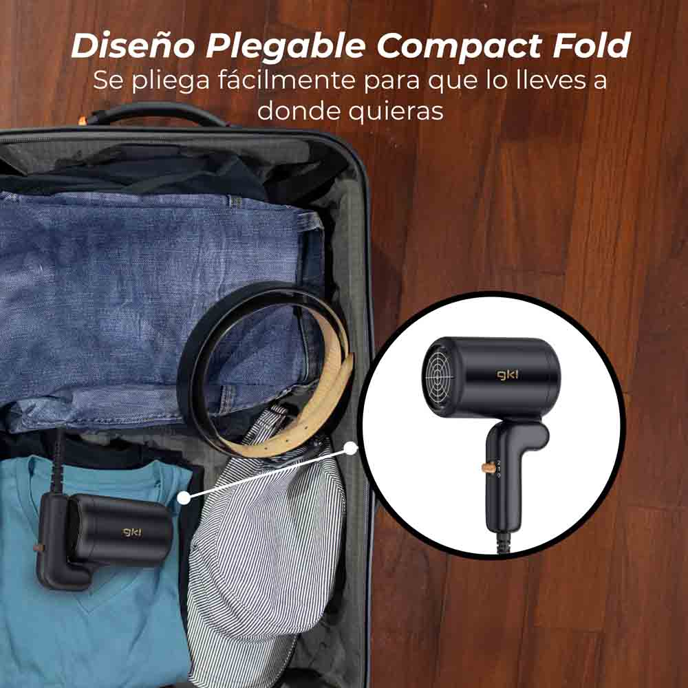 Un secador de pelo negro en una maleta con ropa. El secador está a la derecha, con un fondo blanco.