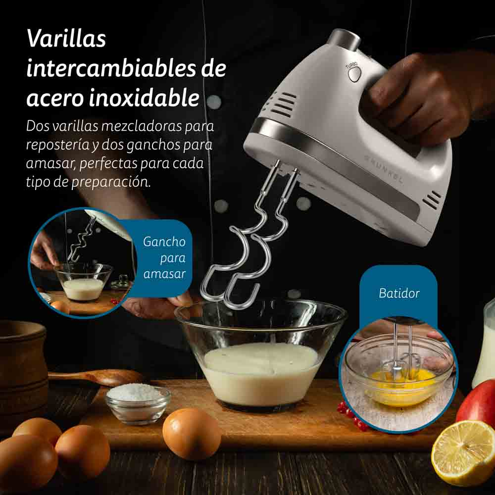 Un frullatore a mano con fruste in acciaio inossidabile e una ciotola di pastella. Altri ingredienti sullo sfondo.