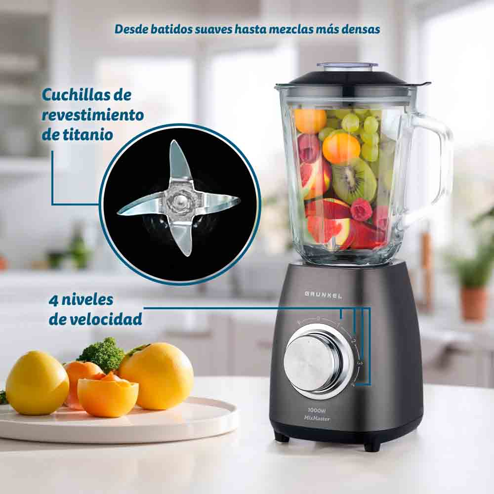 Frullatore con contenitore di vetro pieno di frutta. Dettaglio lama. 4 impostazioni di velocità. Limoni, arancia, broccoli su un piatto.