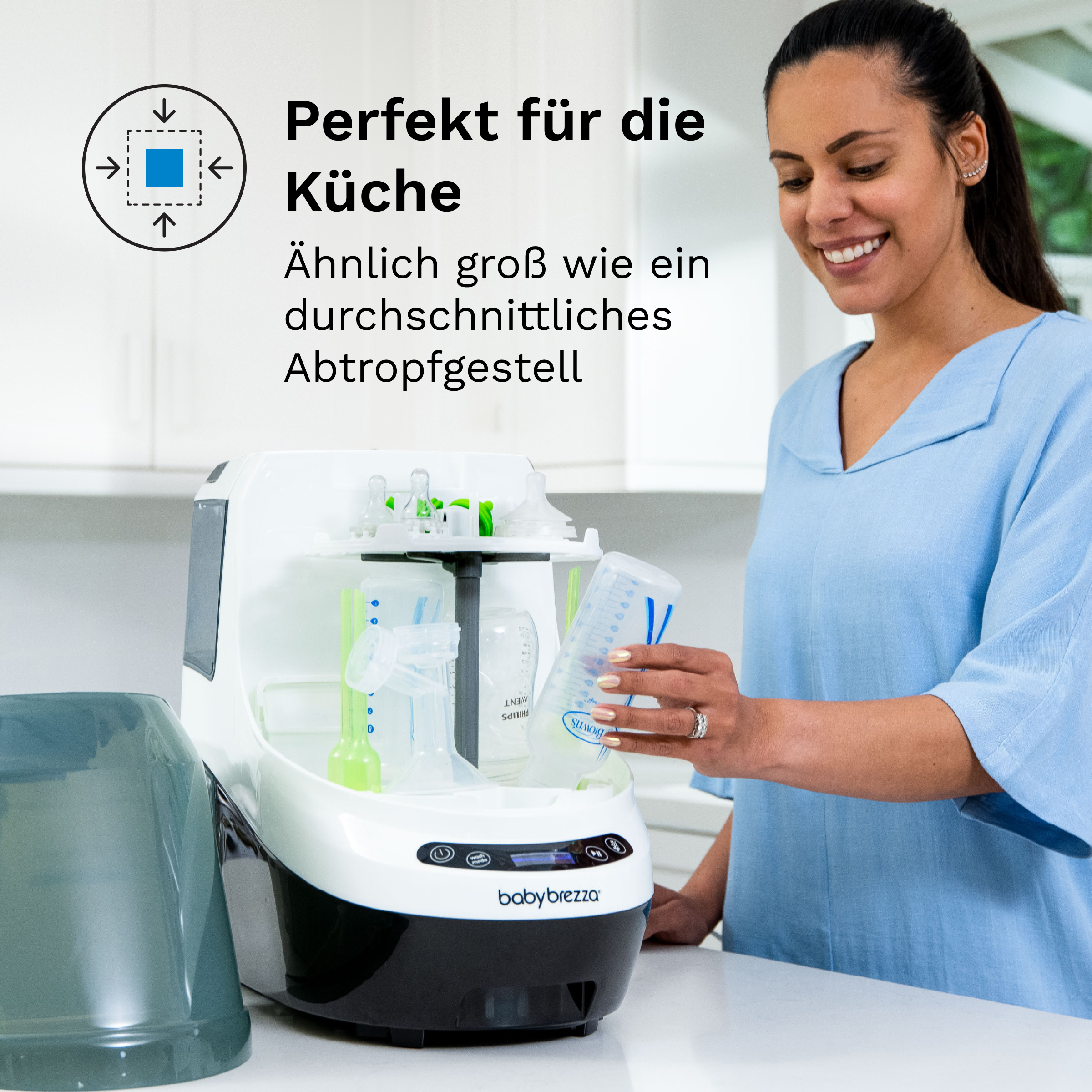 Lächelnde Frau mit Babyflasche am Sterilisator. Küchenhintergrund.