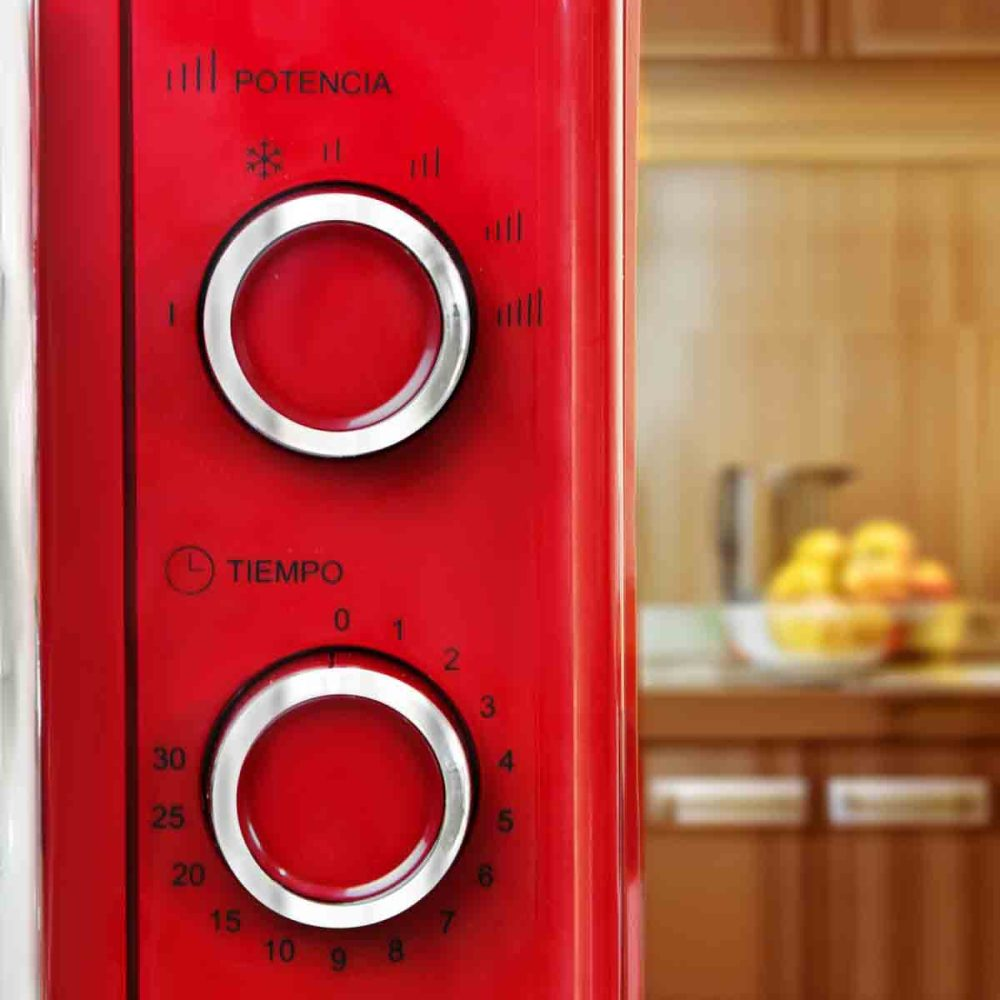Panel de control de microondas rojo. Perillas de potencia y tiempo. Fondo de cocina.