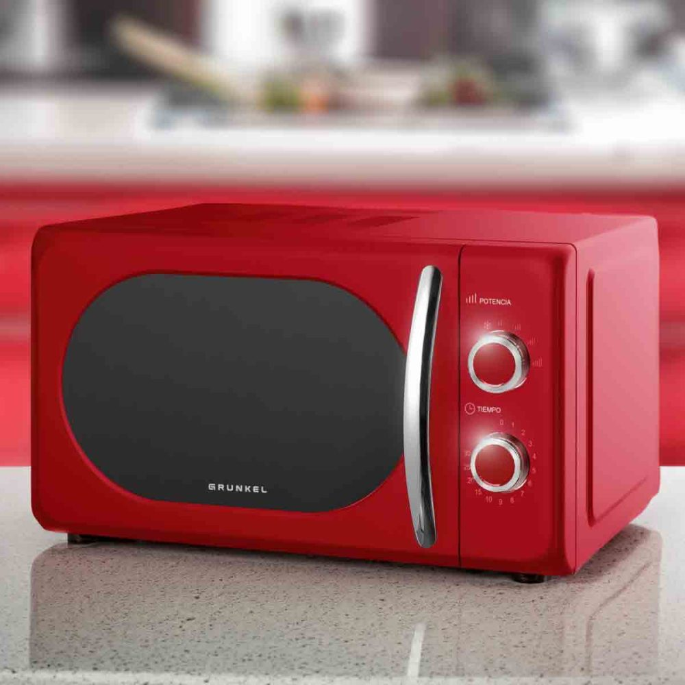 Un horno microondas rojo con puerta negra y asa plateada. Se ve la marca 'Grunkel'.
