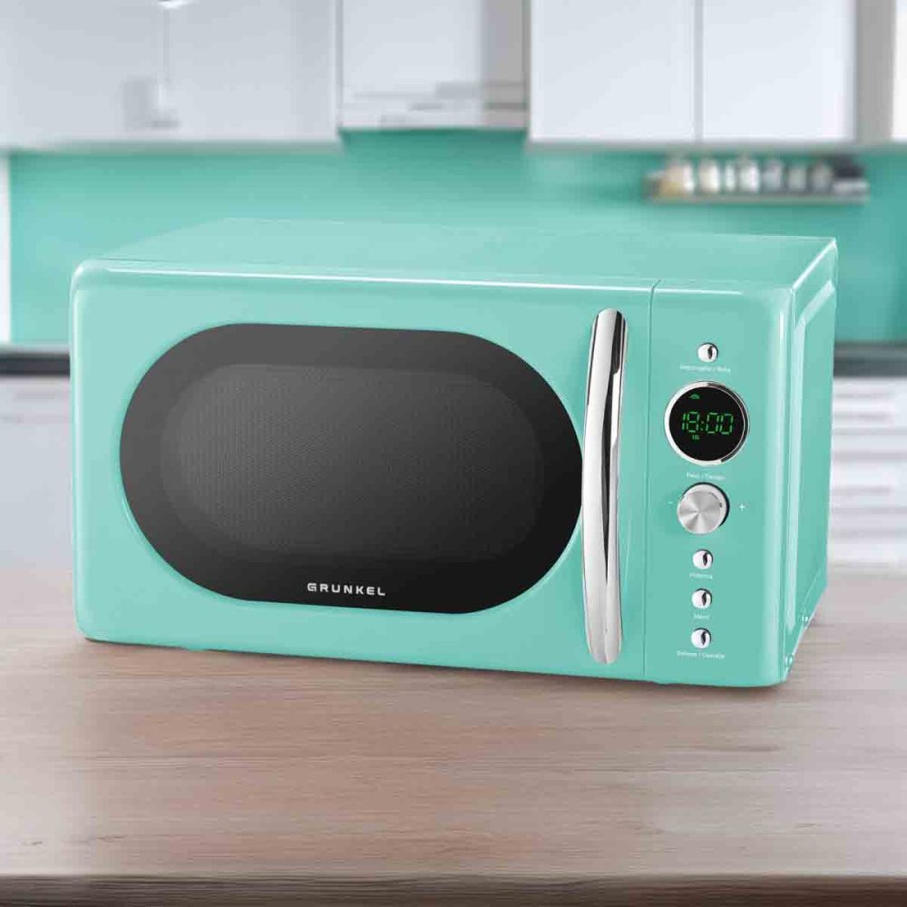 Un horno microondas turquesa sobre una superficie de madera, con ventana ovalada y pantalla digital.
