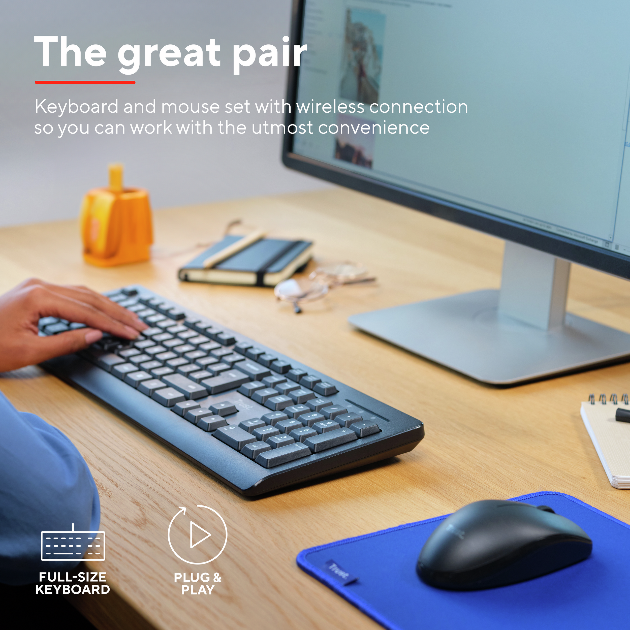 Klawiatura i mysz na drewnianym biurku. Monitor wyświetla ekran i inne przedmioty.