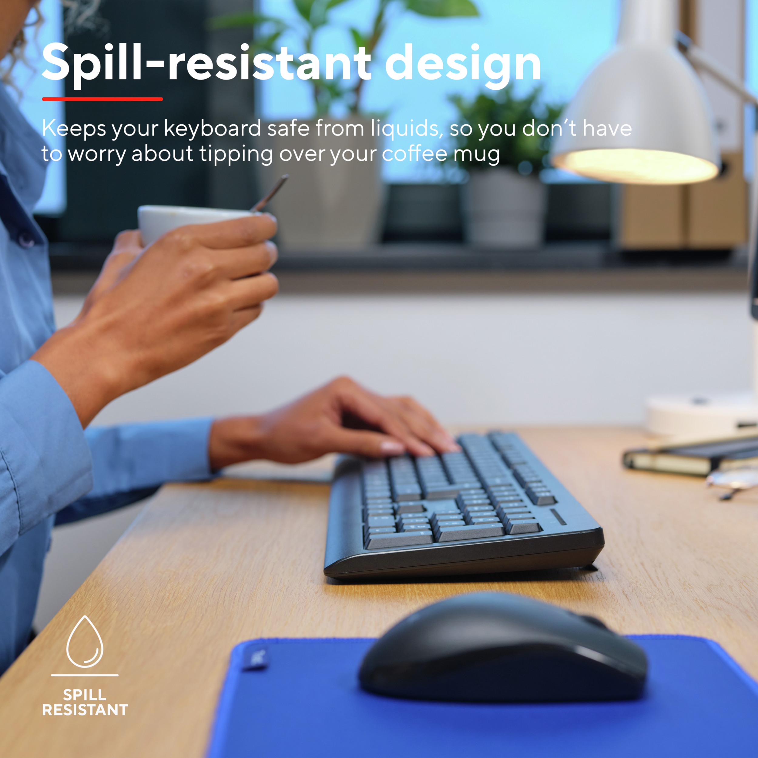 Osoba trzymająca filiżankę nad klawiaturą, z myszą i matą odporną na rozlanie.