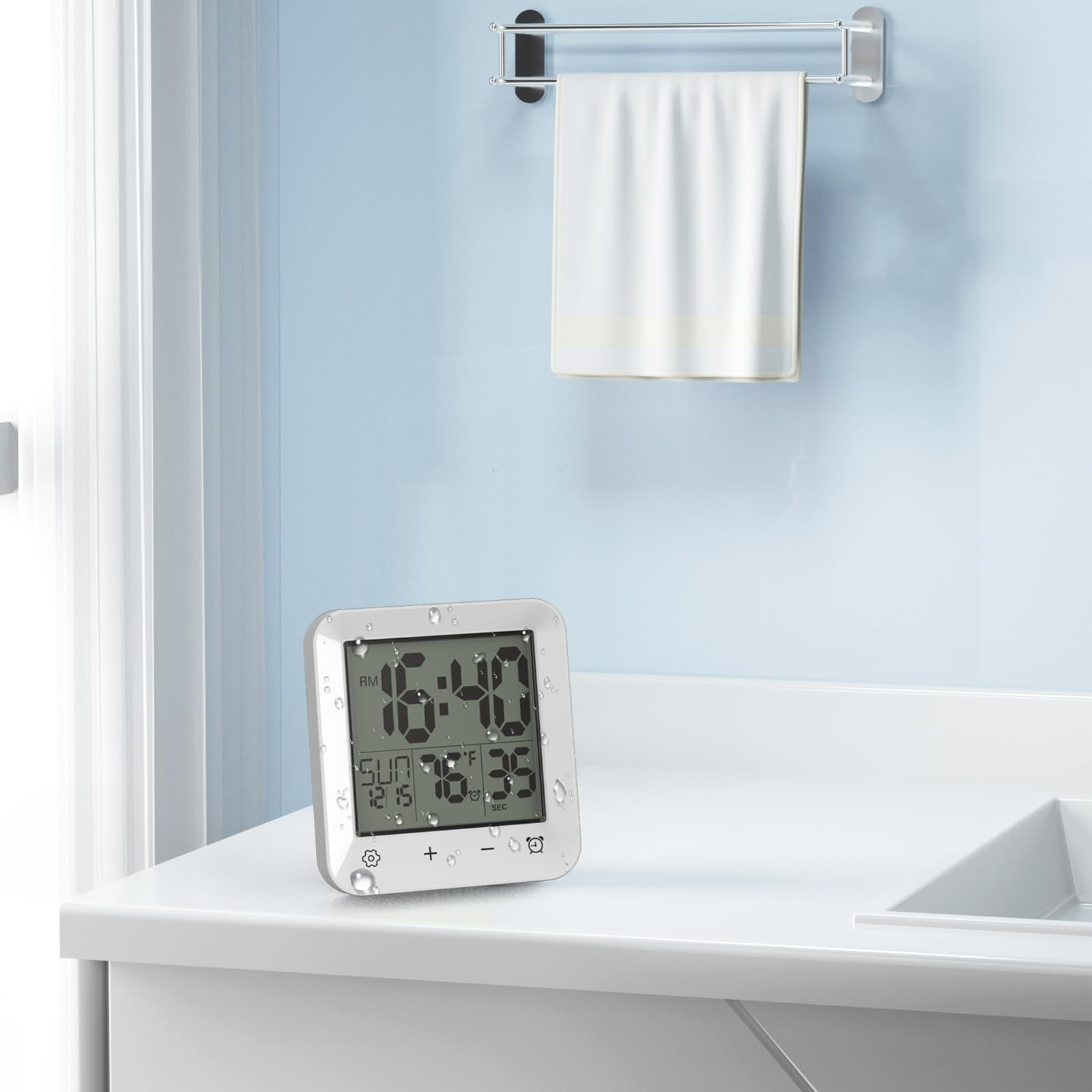 Digitaluhr mit Zeit- und Temperaturanzeige auf einer weißen Arbeitsplatte im Badezimmer.