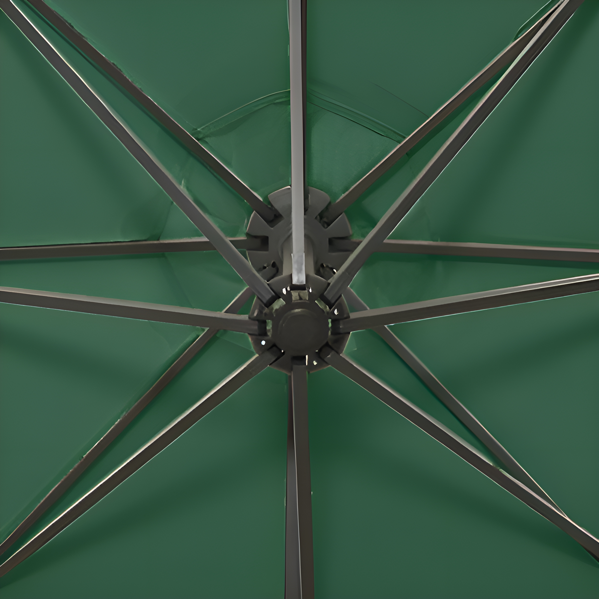 Grüner Regenschirm von innen, Rippen und Obermechanismus zeigend. Dunkelgraue Metallstruktur.