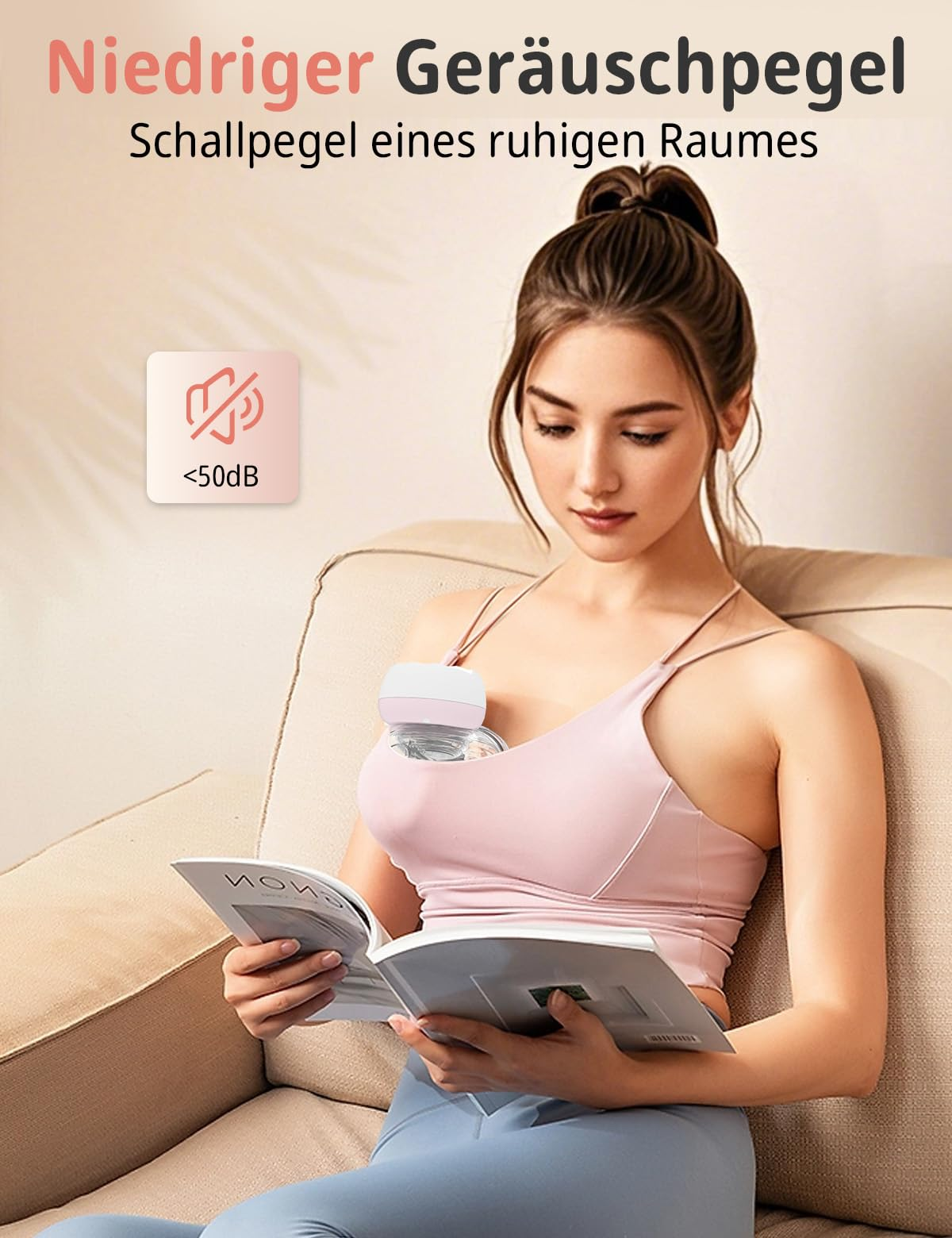 Eine Frau in einem rosa Oberteil liest ein Buch, während sie eine Brustpumpe trägt.
