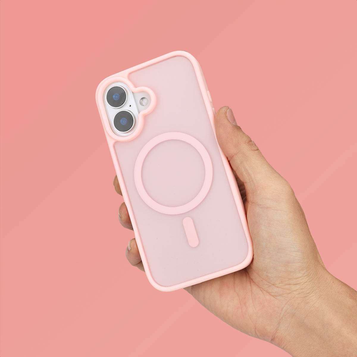 Hand die een roze telefoonhoes vasthoudt met een magnetische ring. De achtergrond is roze.