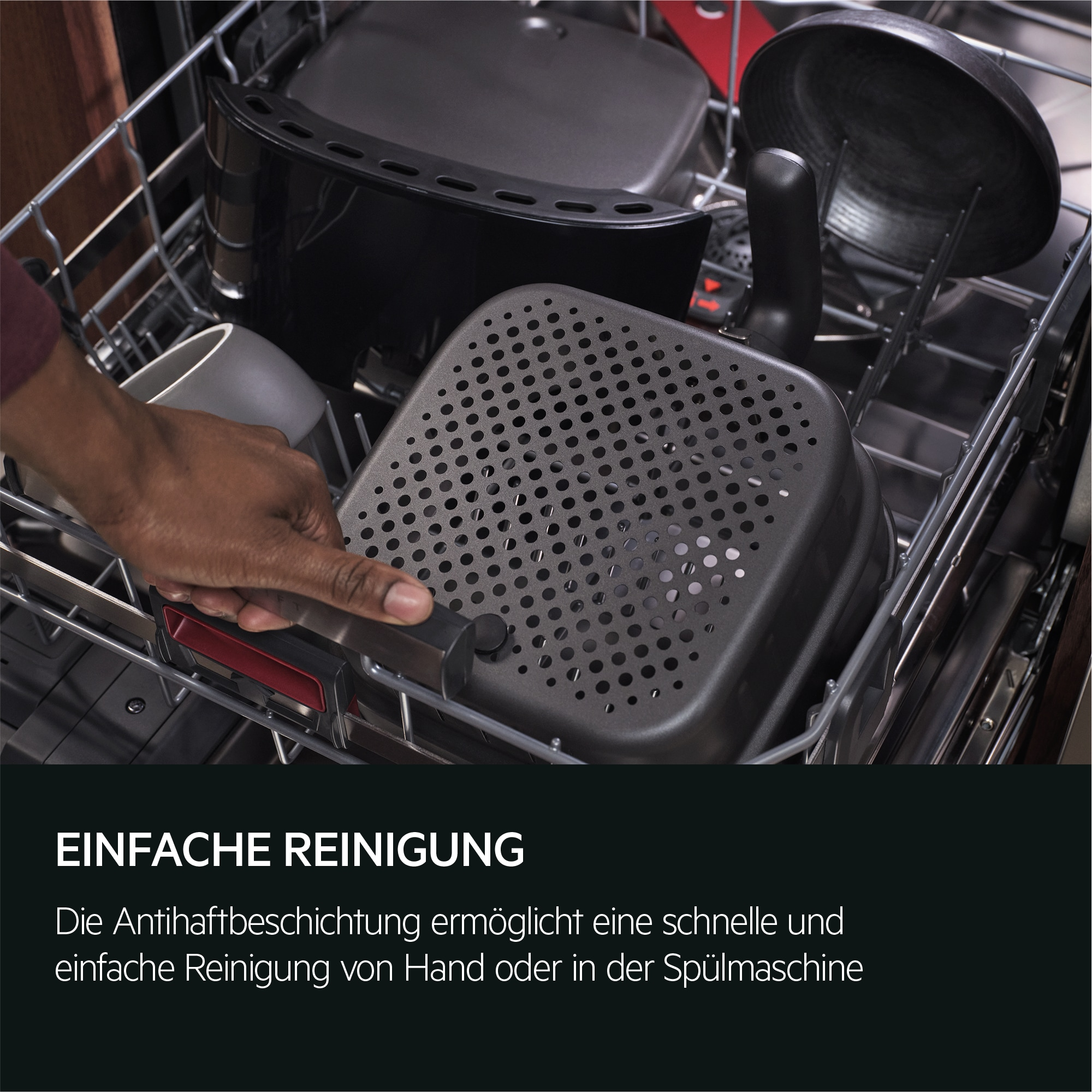 Ręka trzyma czarną kwadratową patelnię w zmywarce. Inne przedmioty są w zmywarce.