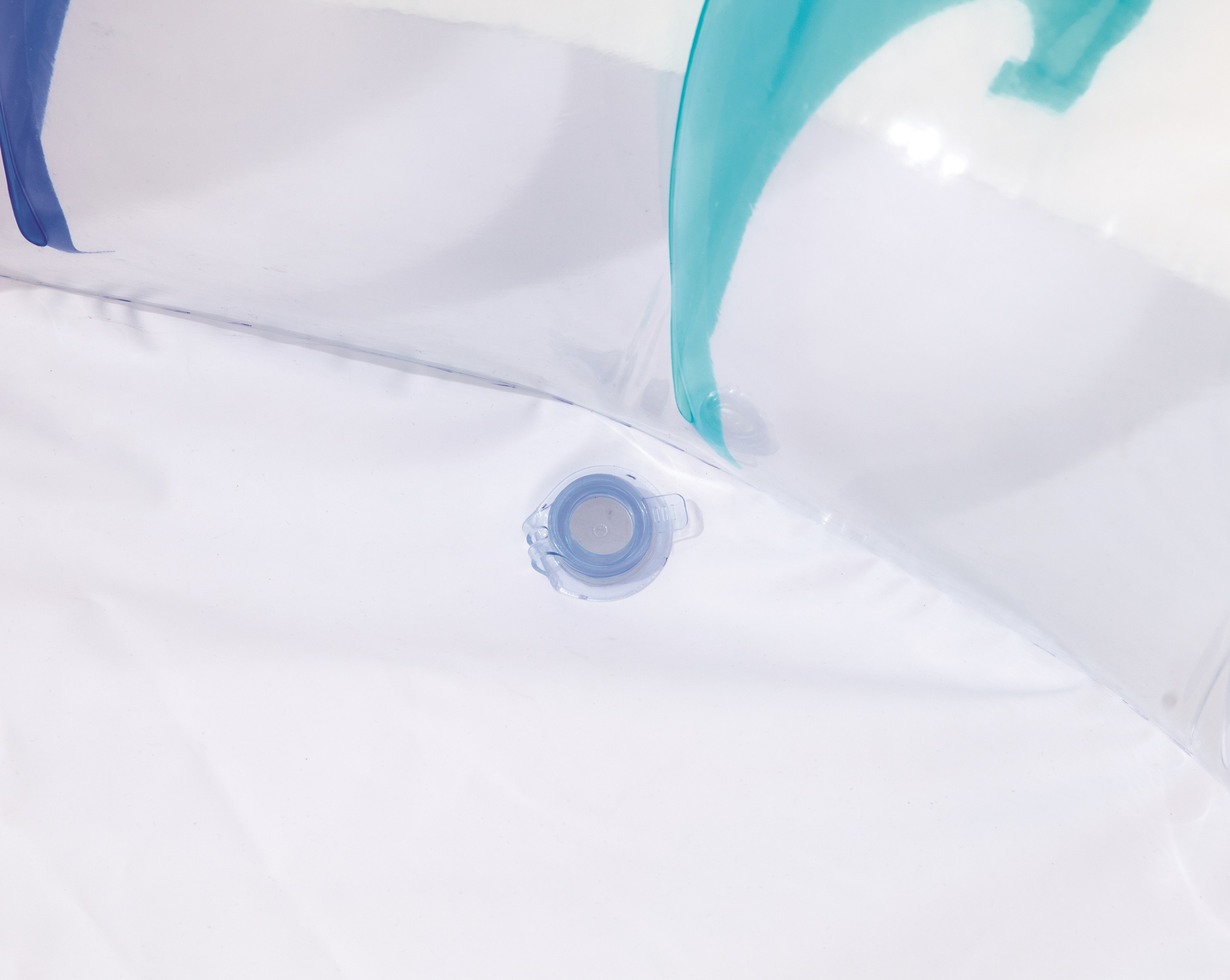 Gros plan d'un jouet de piscine gonflable avec une valve. Le jouet est blanc et transparent.
