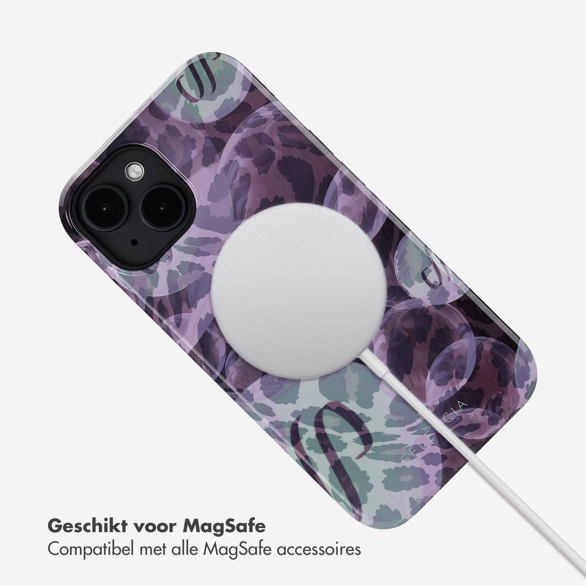 Telefoonhoesje met paars bellenpatroon. Een witte MagSafe-oplader is bevestigd.