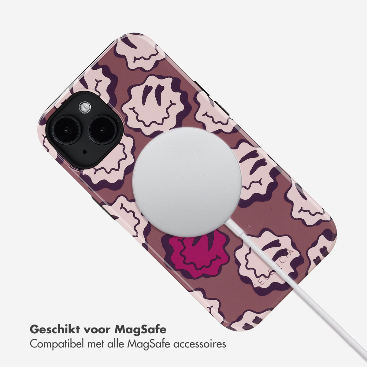 Telefoon met een smiley-gezicht-ontwerp, MagSafe-oplader bevestigd. Witte achtergrond.