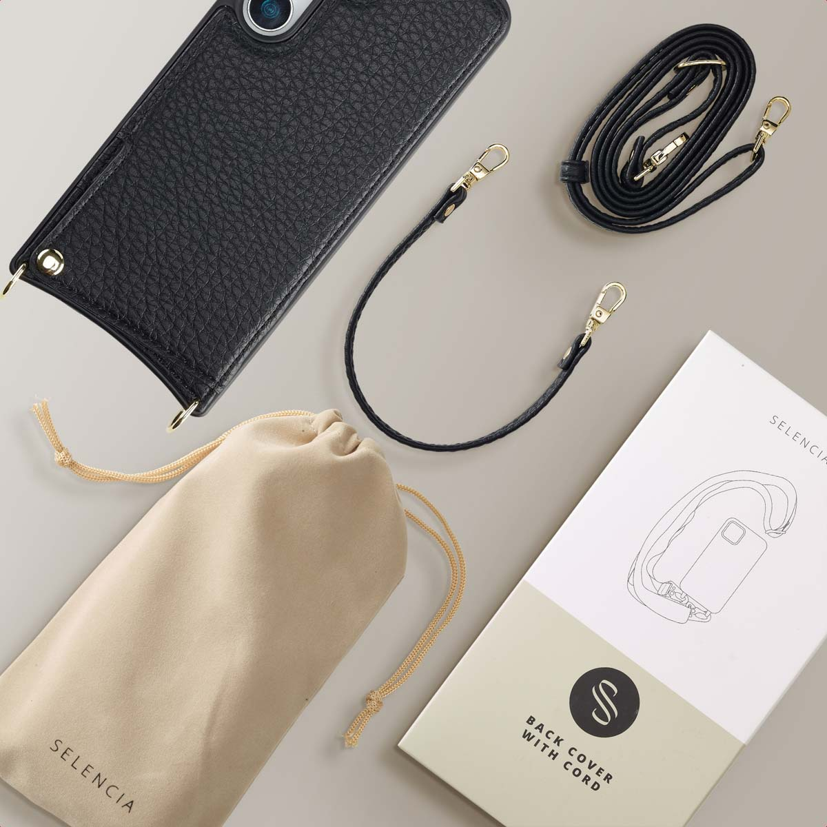 Custodia per telefono nera con cinturino e accessori. Sfondo bianco. Borsa e scatola.