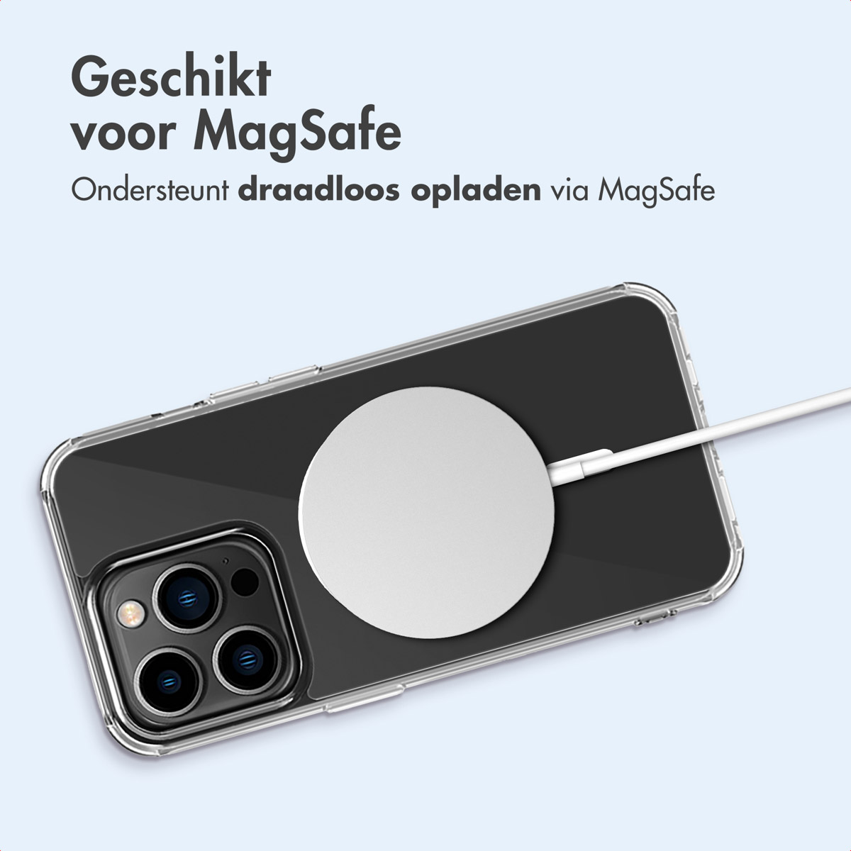 Telefono nero in custodia trasparente, caricatore MagSafe bianco attaccato. Cavo bianco. Sfondo blu.