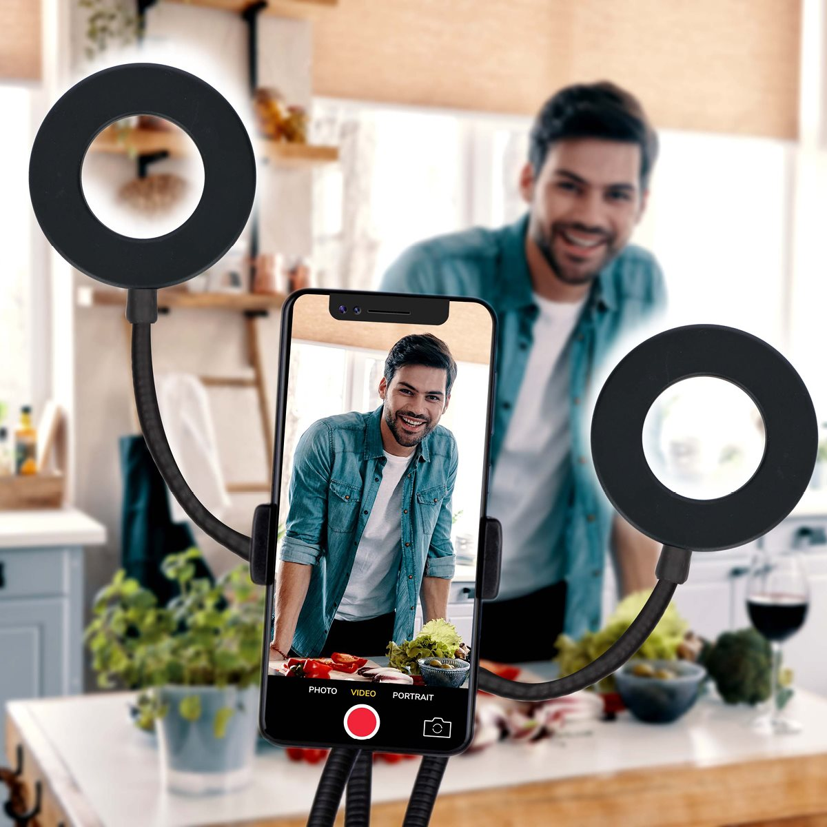 A man is recording video. A ring light and a phone stand are used to hold the phone.