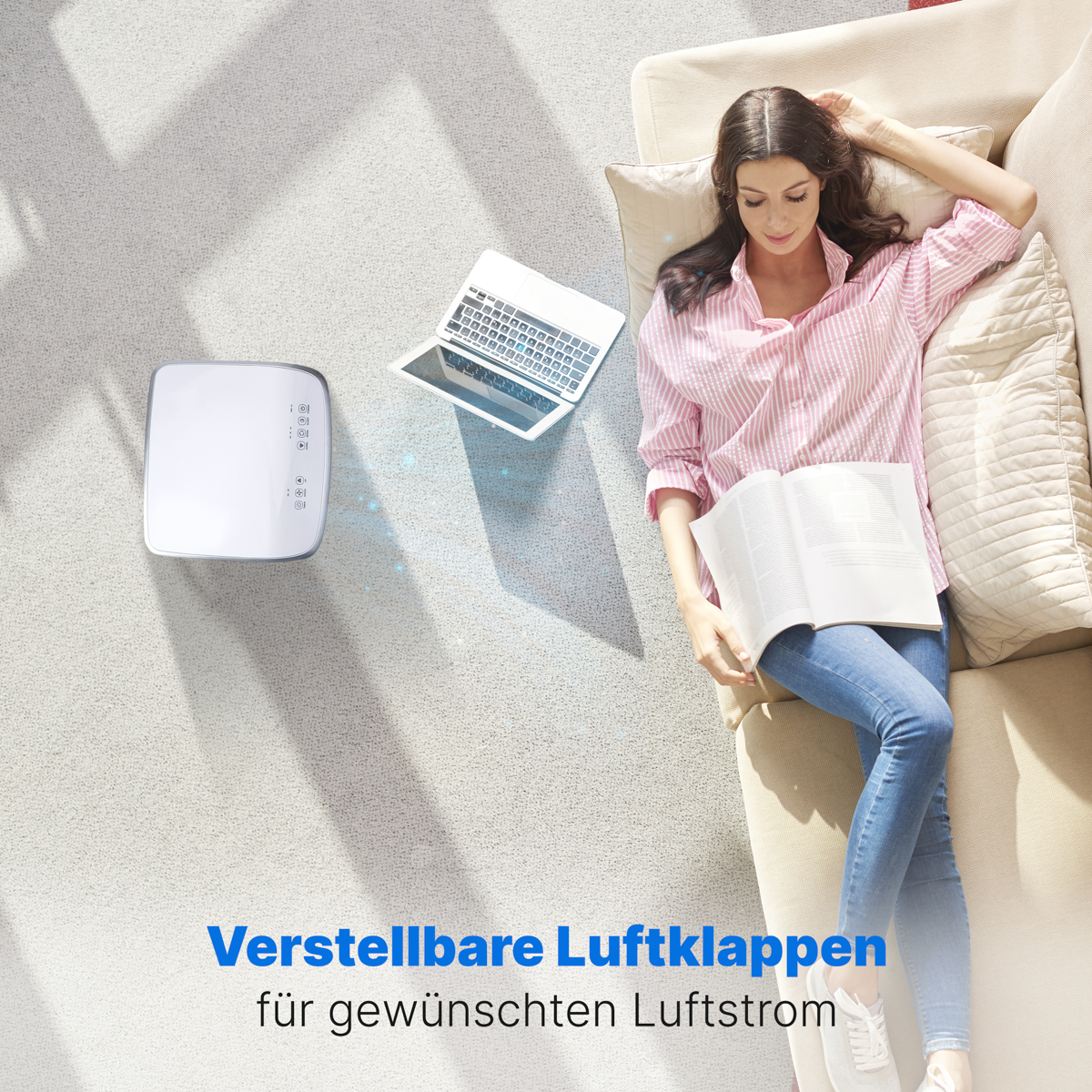 Eine Frau liegt auf einer Couch mit einem Laptop und einem weißen Luftreiniger daneben.