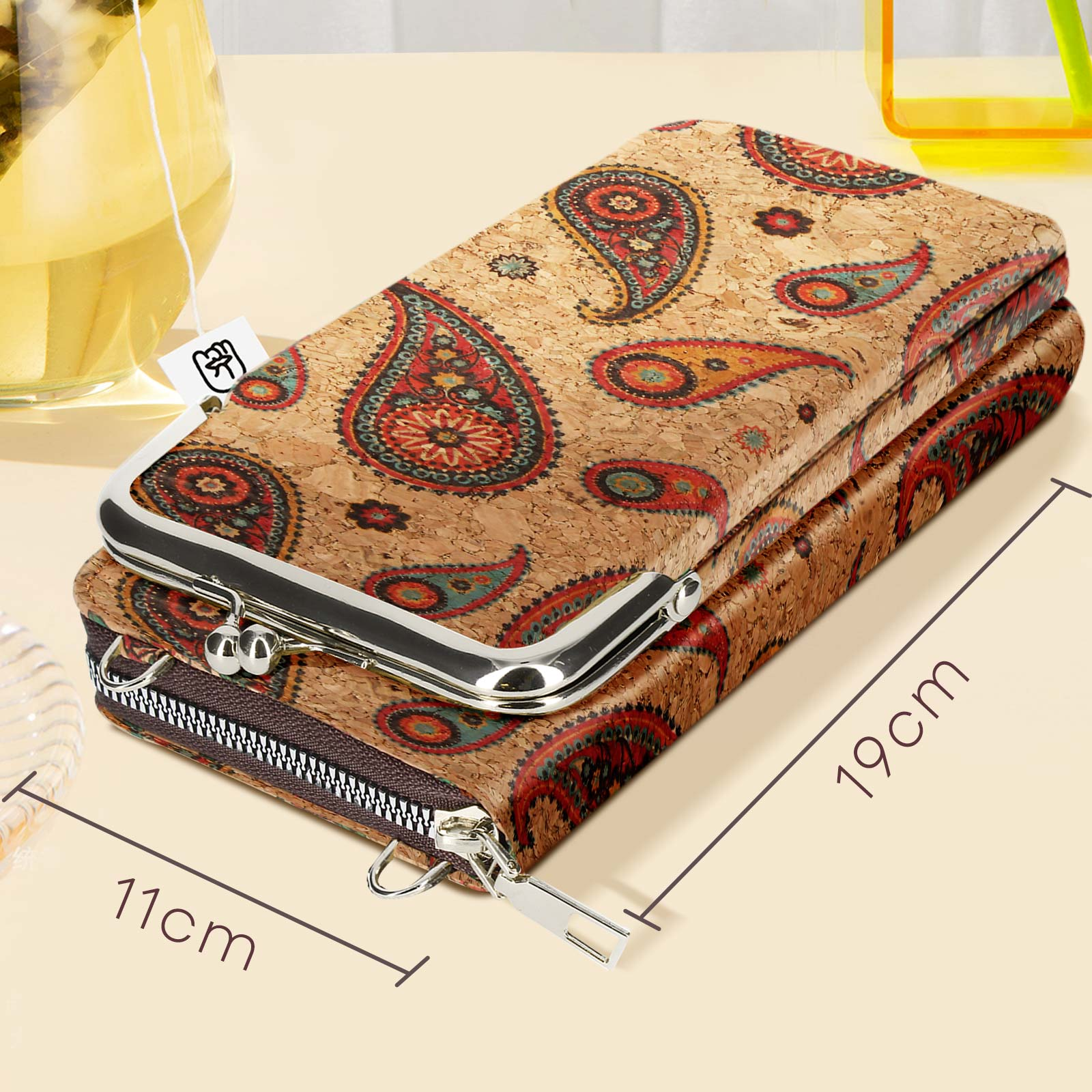 Eine braune Geldbörse mit Paisley-Muster ist geöffnet. Die Geldbörse liegt auf einer hellen Oberfläche. Die Abmessungen sind angegeben.