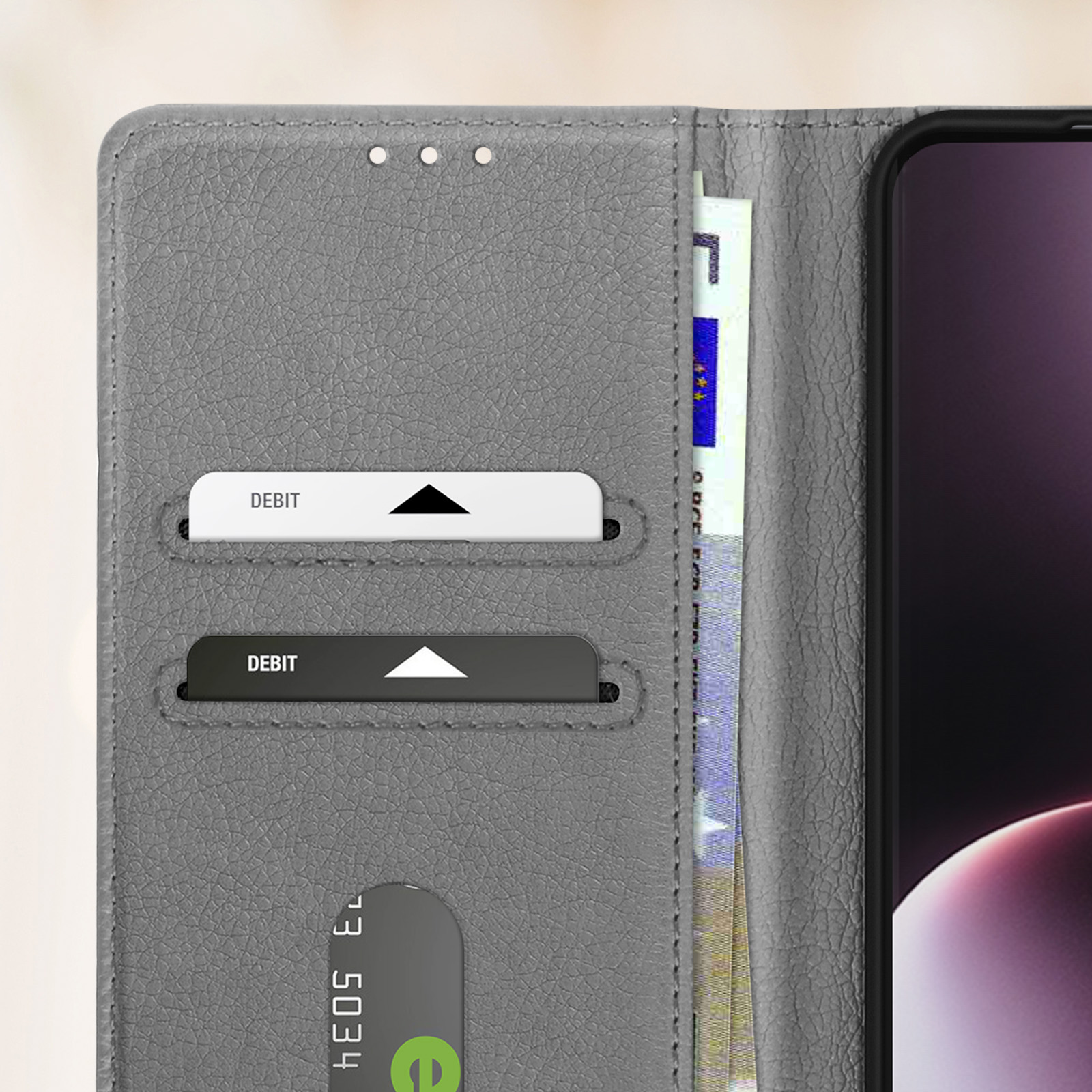 Eine graue Geldbörse, geöffnet mit Debitkarten und einem Geldschein, mit schwarzem Telefon.