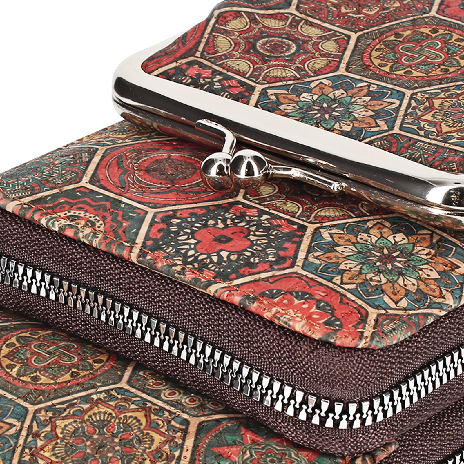 Nahaufnahme einer gemusterten Geldbörse mit Metallverschluss und Reißverschluss. Das Muster ist floral und geometrisch.