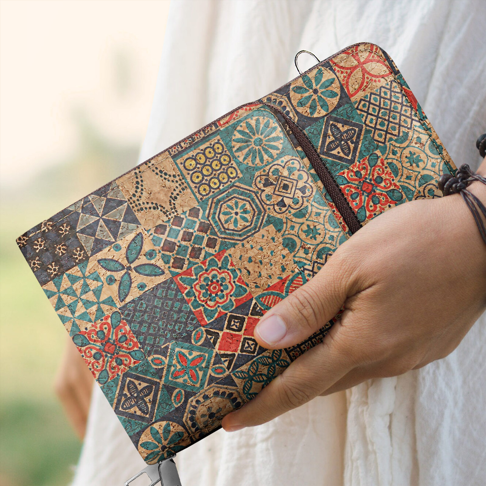 Eine Person hält ein gemustertes Journal. Das Journal hat ein Patchwork-Design mit verschiedenen Farben und geometrischen Formen.