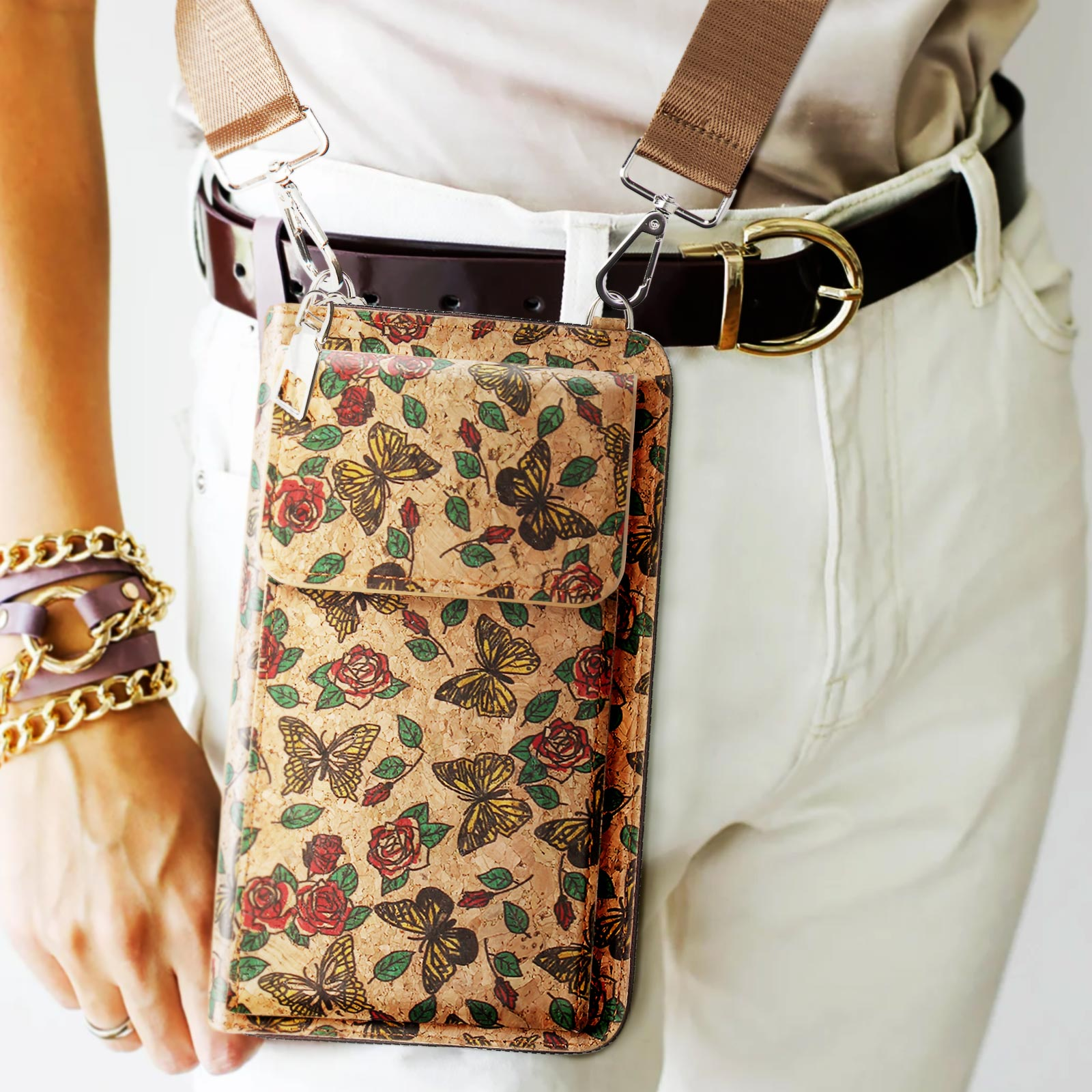 Frau, die eine Handytasche mit Schmetterlingen und Blumen trägt, an einem Gurt über der Brust.