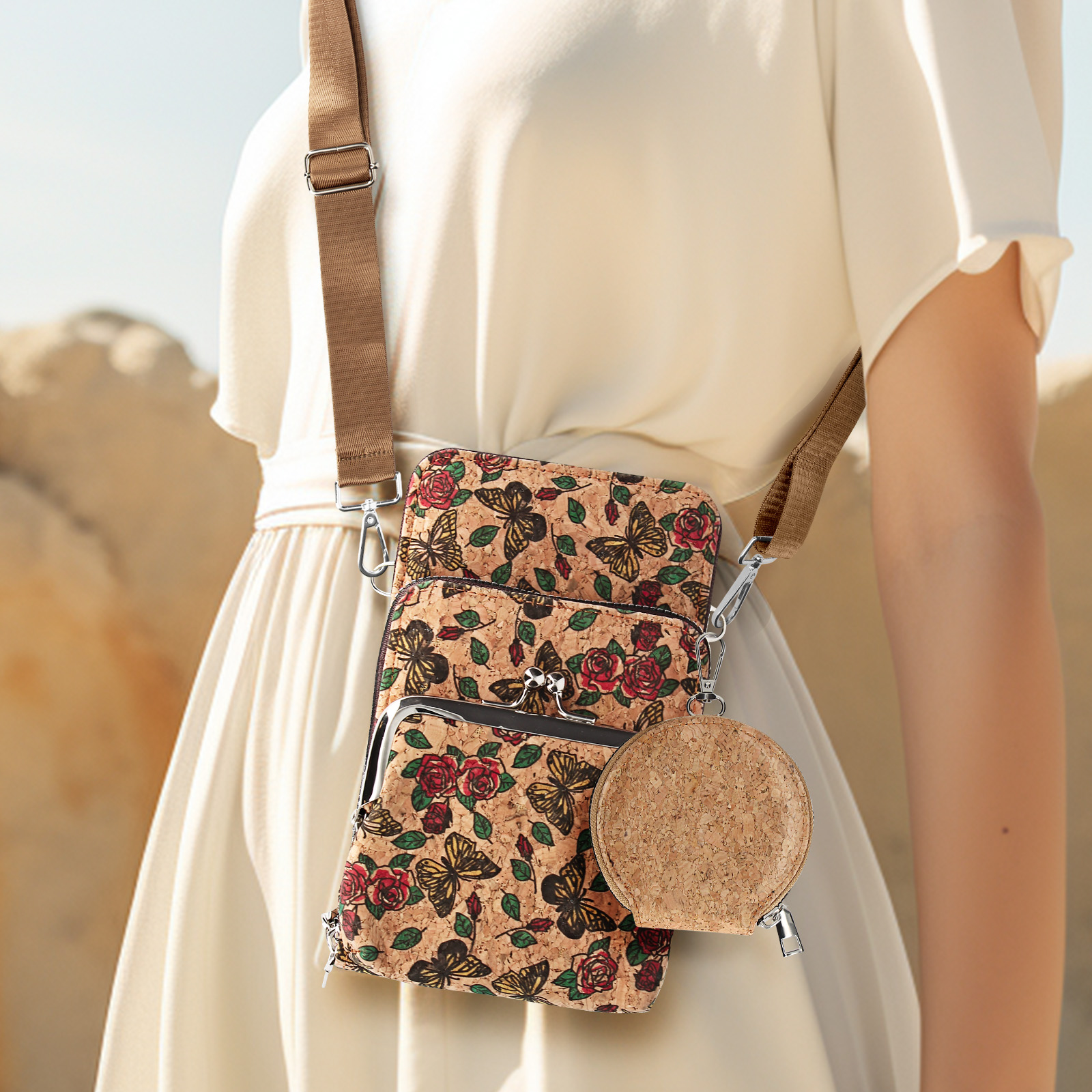Frau, die drei Crossbody-Telefontaschen trägt. Korkmaterial mit Schmetterlings- und Rosenmuster.
