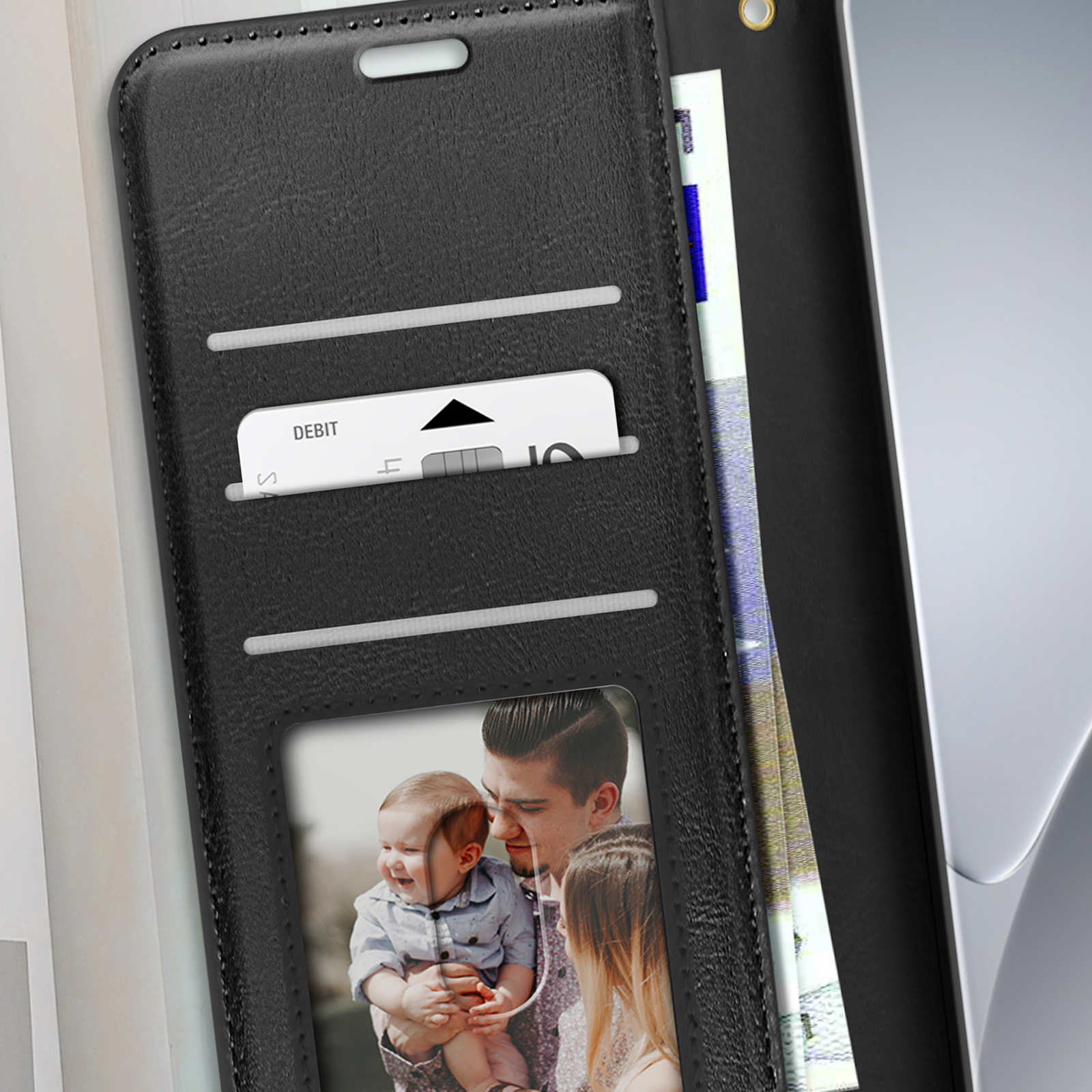 Schwarze Handyhülle mit Karte, Foto und Geld. Grauer Hintergrund.