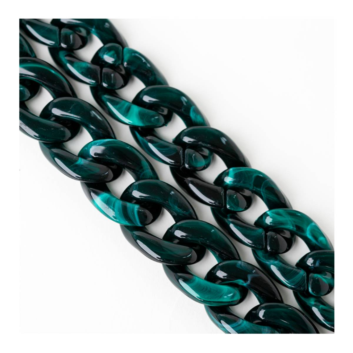 Primo piano di una catena verde scuro con effetto malachite, maglie su sfondo bianco.